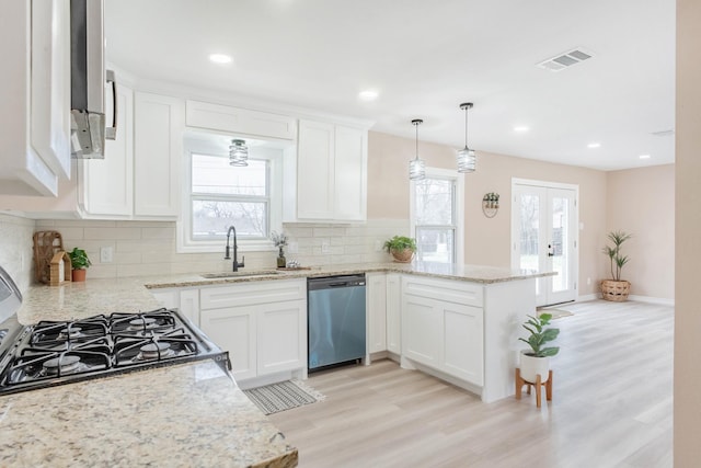 kitchen with sink, stainless steel dishwasher, pendant lighting, decorative backsplash, and white cabinets