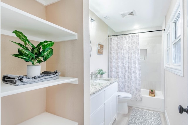 full bathroom with hardwood / wood-style flooring, vanity, shower / tub combo, and toilet