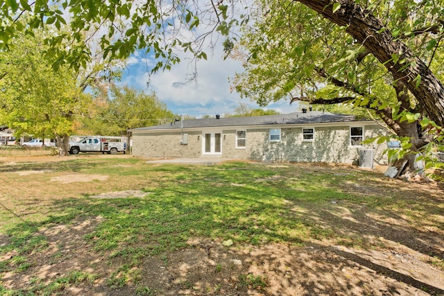 back of house featuring central AC and a lawn