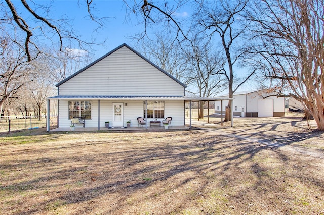 back of property featuring a lawn and covered porch