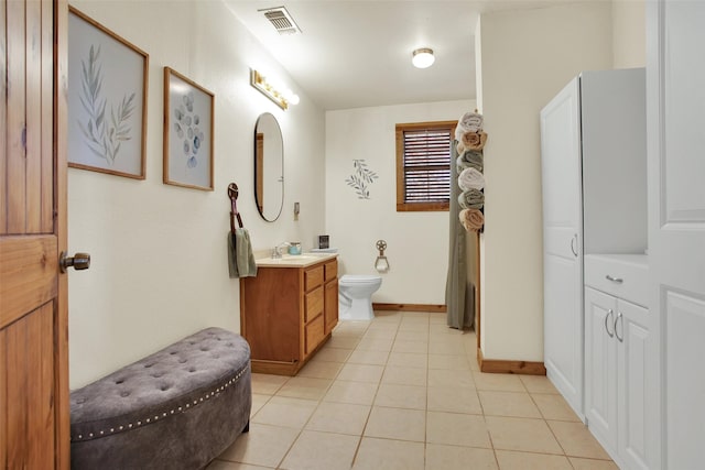 bathroom with tile patterned flooring, vanity, and toilet