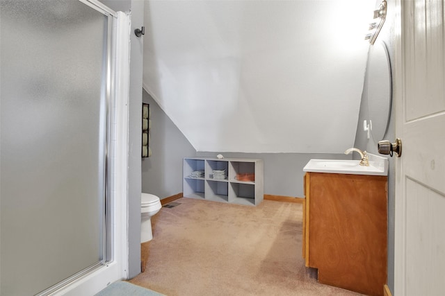 bathroom with vanity, vaulted ceiling, a shower with door, and toilet