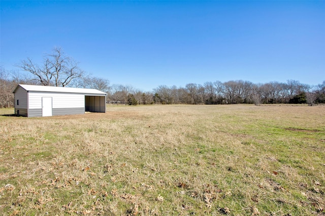 view of yard featuring an outdoor structure and a rural view