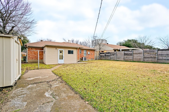 back of property featuring an outdoor structure, central AC unit, and a lawn