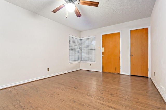 spare room with hardwood / wood-style flooring, ceiling fan, and a textured ceiling