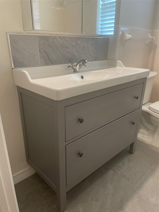 bathroom featuring vanity, tile patterned flooring, and toilet