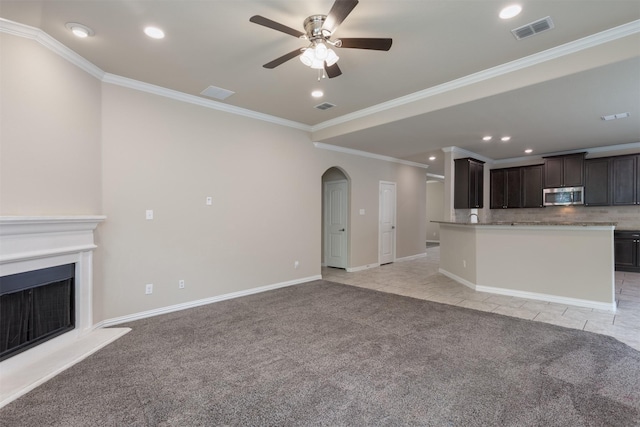 unfurnished living room with ornamental molding, light colored carpet, and ceiling fan