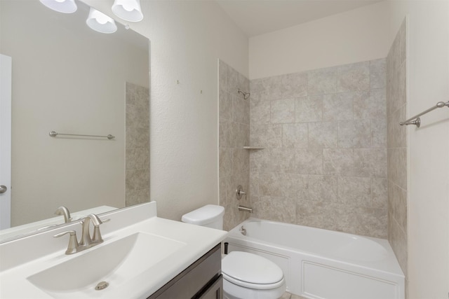 full bathroom with tiled shower / bath, vanity, and toilet