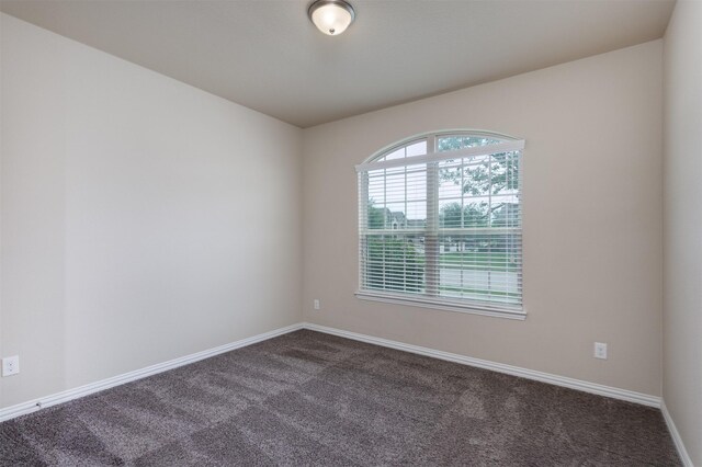 carpeted spare room with ceiling fan and vaulted ceiling