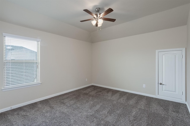 spare room featuring ceiling fan, lofted ceiling, and dark colored carpet