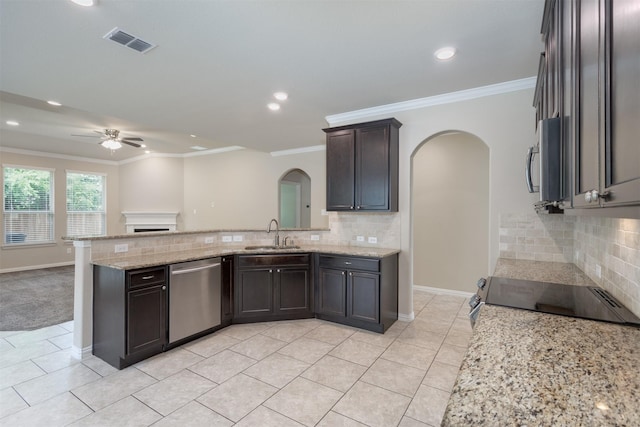 kitchen featuring light stone counters, stainless steel appliances, crown molding, and sink