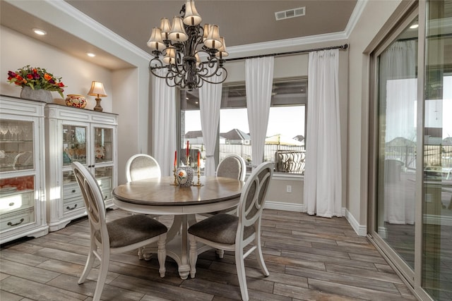 dining space with crown molding and a notable chandelier