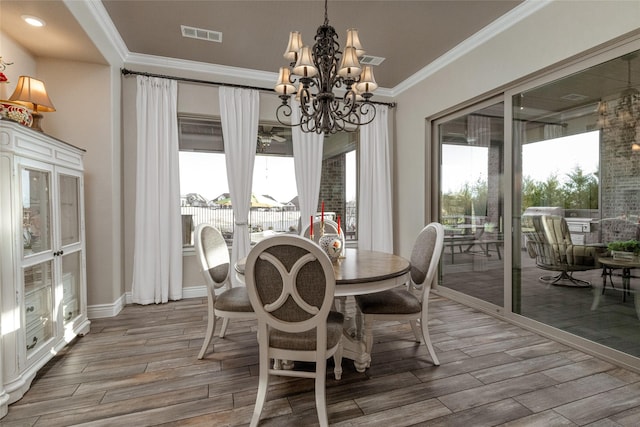 dining room with an inviting chandelier, crown molding, and french doors