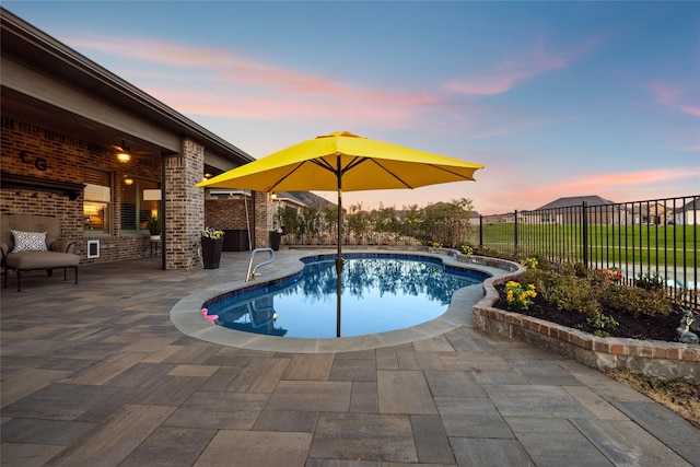 pool at dusk featuring a patio area