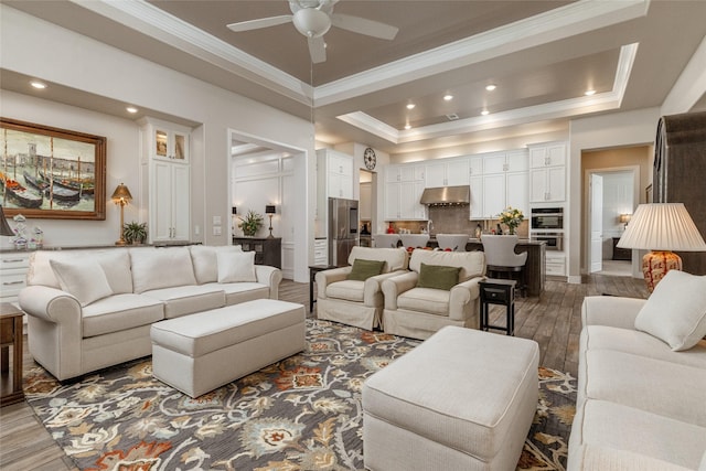 living room with dark hardwood / wood-style flooring, ornamental molding, a raised ceiling, and ceiling fan