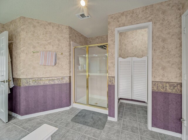 bathroom with visible vents, wallpapered walls, a stall shower, a textured ceiling, and tile patterned floors