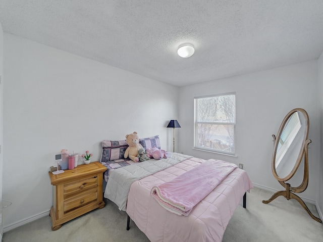 bedroom with light carpet, baseboards, and a textured ceiling