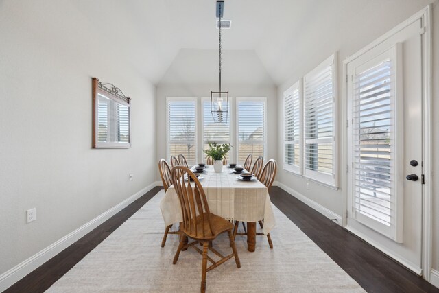 dining room featuring vaulted ceiling, dark wood-type flooring, and a chandelier