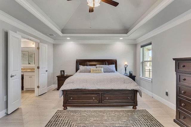 bedroom featuring crown molding, ceiling fan, ensuite bathroom, and a raised ceiling