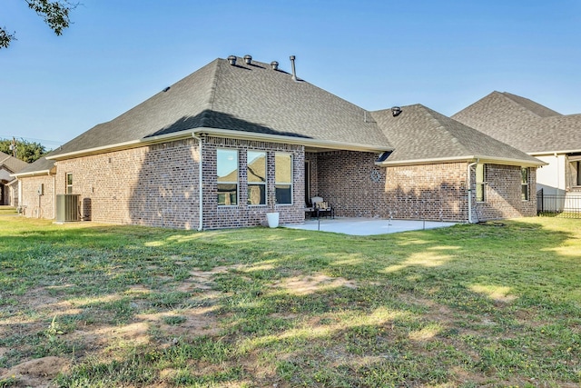 back of property with a lawn, central air condition unit, and a patio area