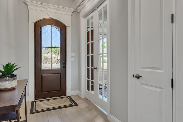 doorway to outside with ornamental molding and light hardwood / wood-style floors