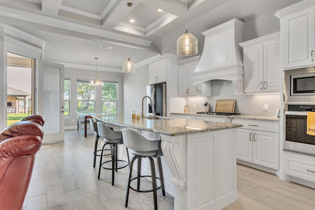 kitchen featuring white cabinetry, stainless steel appliances, a kitchen island with sink, and custom exhaust hood