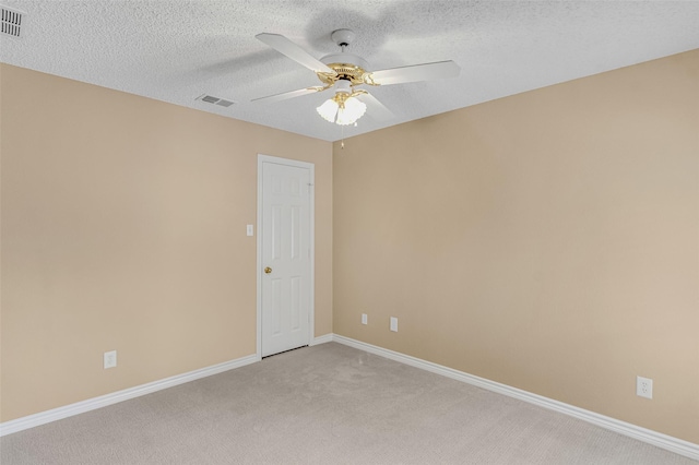 carpeted spare room with a textured ceiling and ceiling fan