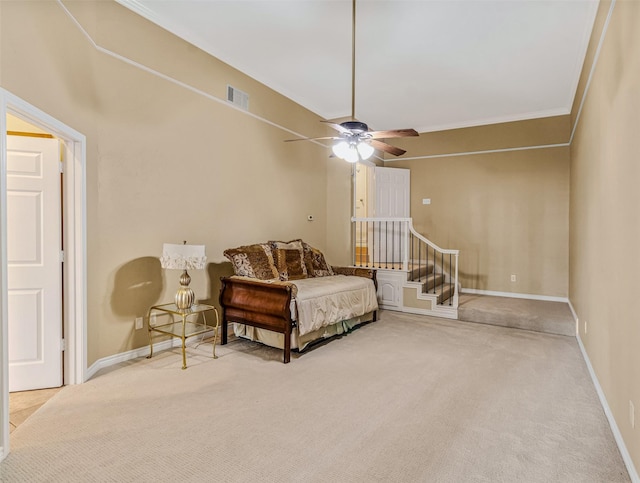 carpeted bedroom with ornamental molding and ceiling fan