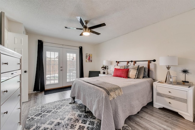 bedroom featuring hardwood / wood-style flooring, access to exterior, ceiling fan, a textured ceiling, and french doors