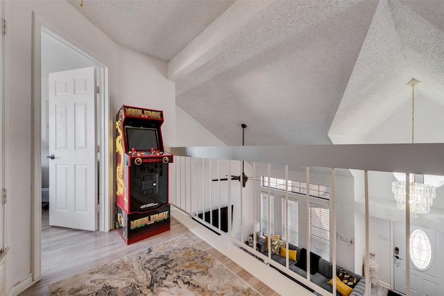 interior space with lofted ceiling, a notable chandelier, hardwood / wood-style flooring, and a textured ceiling