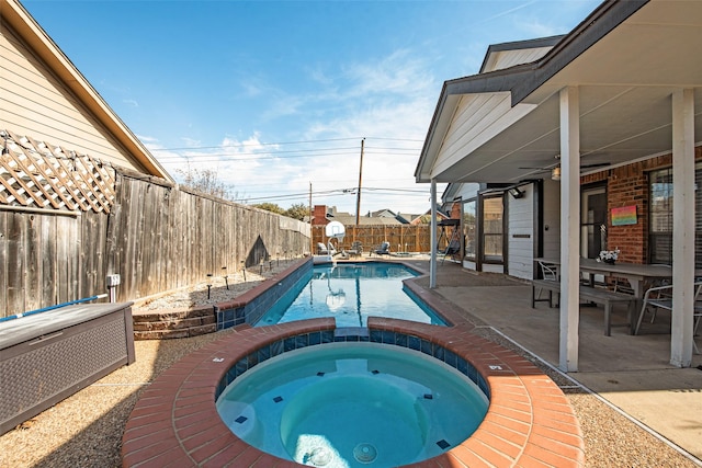 view of pool with a patio, ceiling fan, and an in ground hot tub