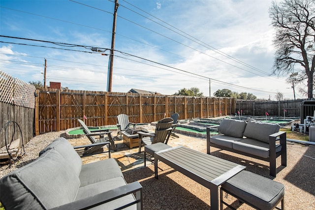 view of patio with a fenced in pool and an outdoor living space with a fire pit