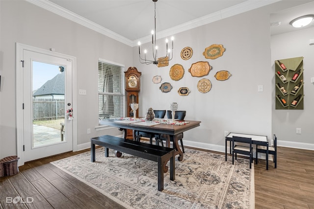 dining room with hardwood / wood-style floors, crown molding, and a chandelier