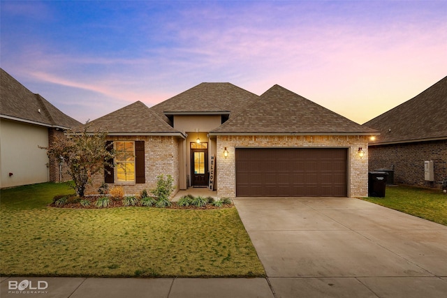 view of front facade featuring a garage and a lawn