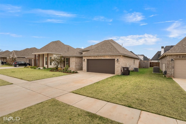 view of front of home with a garage, a front yard, and central air condition unit