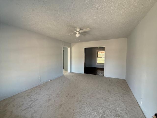 carpeted spare room with ceiling fan and a textured ceiling