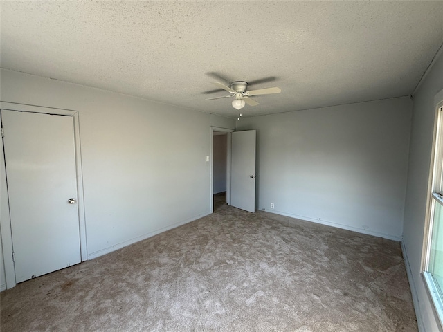 unfurnished bedroom featuring light carpet, a textured ceiling, ceiling fan, and a closet