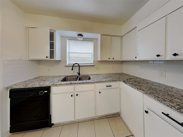 kitchen featuring sink, light stone countertops, white cabinets, and black dishwasher