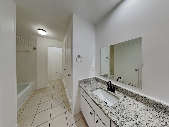 bathroom with tile patterned flooring, vanity, and tiled shower / bath