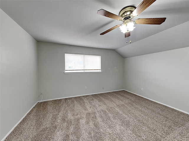 carpeted spare room featuring ceiling fan and vaulted ceiling