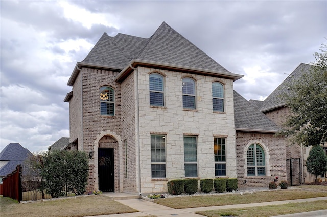 french country inspired facade featuring a front yard