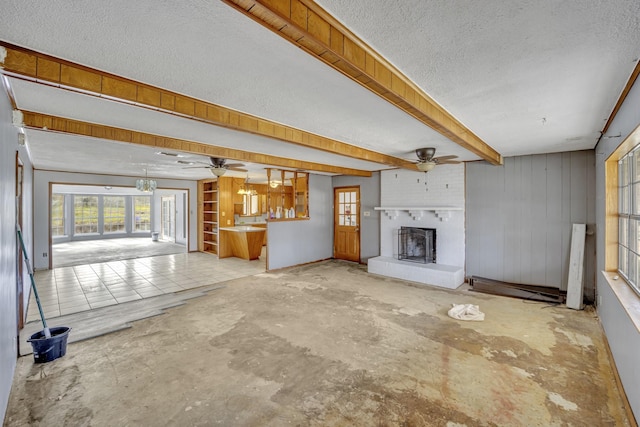 unfurnished living room featuring beam ceiling, a textured ceiling, a fireplace, and ceiling fan