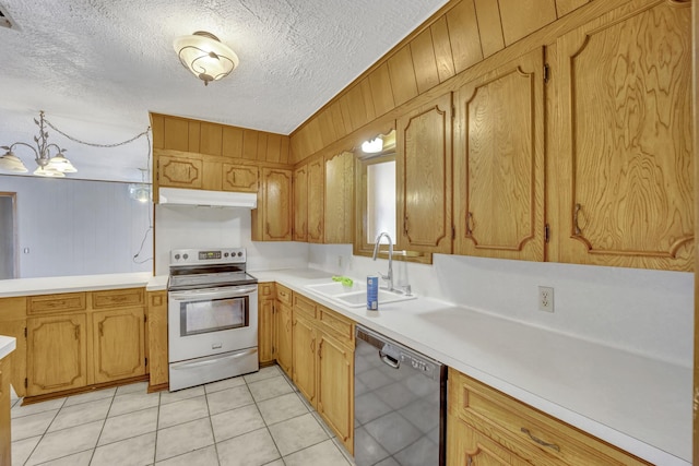 kitchen featuring sink, stainless steel electric range, wooden walls, dishwasher, and pendant lighting