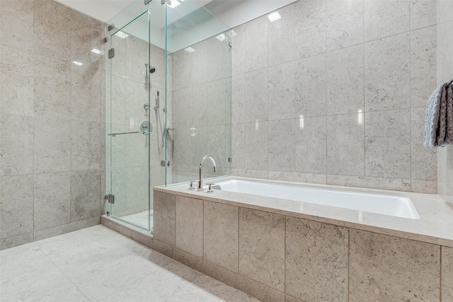 bathroom featuring separate shower and tub, tile patterned flooring, and tile walls