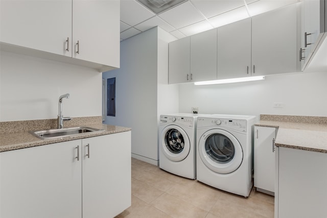 clothes washing area featuring light tile patterned flooring, cabinets, sink, and washing machine and dryer