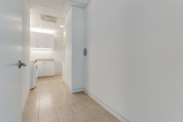 hall with washer / dryer, light tile patterned floors, and a paneled ceiling