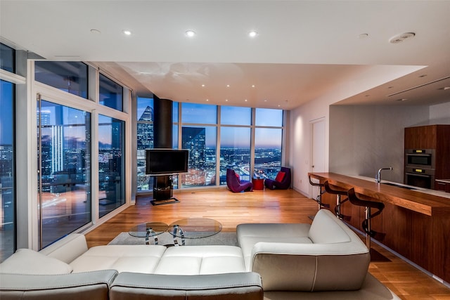 living room featuring hardwood / wood-style flooring, floor to ceiling windows, and sink