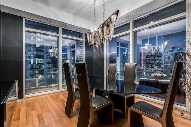 dining room with expansive windows, wood-type flooring, and a notable chandelier