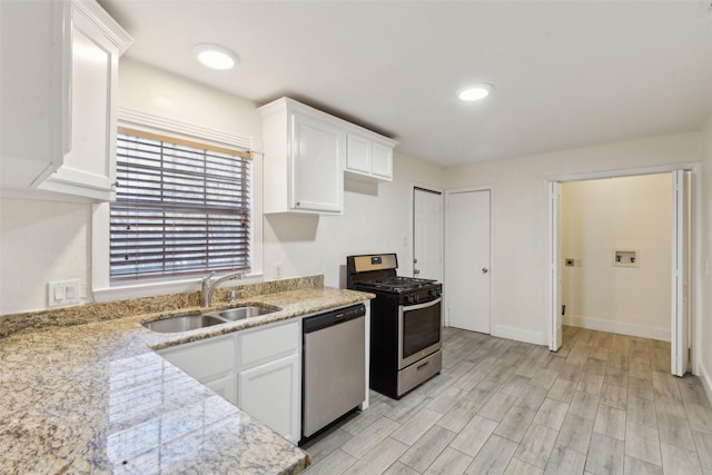 kitchen featuring light stone counters, sink, white cabinets, and appliances with stainless steel finishes