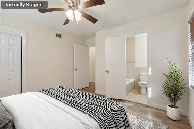 bedroom with ceiling fan, ensuite bathroom, and light hardwood / wood-style flooring